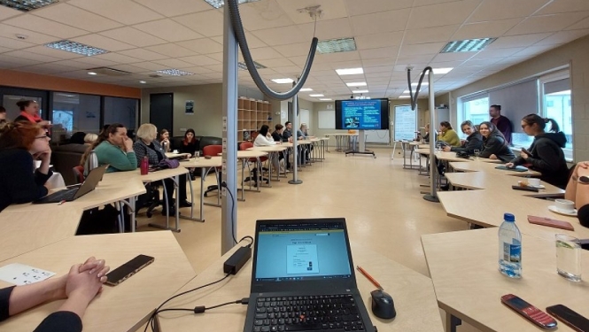 Konferences dalībnieki klausās lekciju